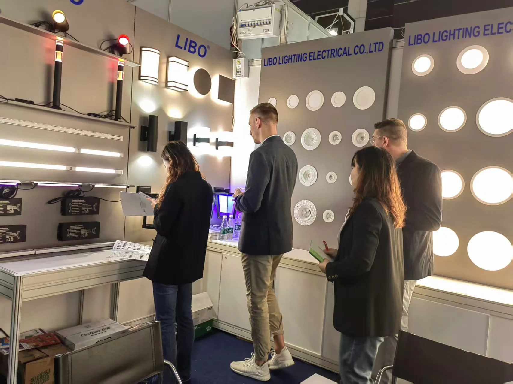 Buyers examining smart ceiling lights at trade show